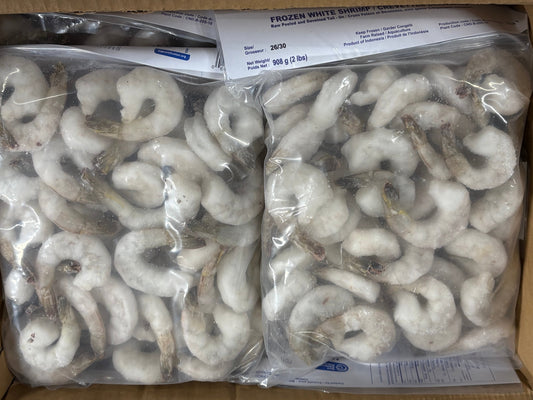 Two clear plastic bags of frozen white shrimp filled with peeled, raw shrimp pieces, placed inside a cardboard box.