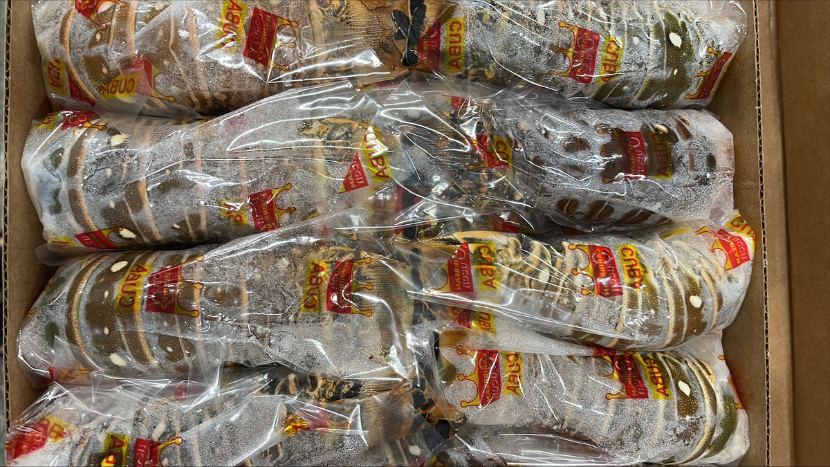 Multiple lobster tails individually wrapped in clear plastic packaging inside a cardboard box.